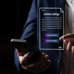 Người đang cầm điện thoại Android với biểu tượng bánh răng và thông báo đồng ý cookie