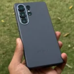 Người dùng cầm điện thoại Galaxy S25 Ultra có ốp lưng Kindsuit màu đen, nền cỏ xanh mát