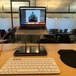 Người dùng chỉnh sửa ảnh trên laptop bằng chuột không dây, nâng cao độ chính xác và thoải mái.