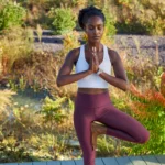 Người phụ nữ tập yoga với đồng hồ Garmin Quatix 6X Solar trên cổ tay, minh họa tính năng theo dõi sức khỏe và thể chất.