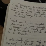 Sổ tay và bút trên bàn, tượng trưng cho việc ghi nhật ký bằng giấy giúp tăng sự tập trung.