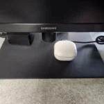 Tai nghe bluetooth đang sạc qua cổng USB trên màn hình máy tính